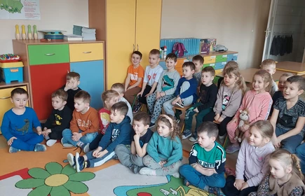 Na zdjęciu grupa przedszkolaków z Publicznego Przedszkola w Łapanowie wraz z panią Celiną Jacewicz oraz uczennicami: Wiktorią Klasło i Justyna Kącką. Zdjęcie wykonane w Publicznym Przedszkolu w Łapanowie podczas warsztatów udzielania pierwszej pomocy przedmedycznej.  