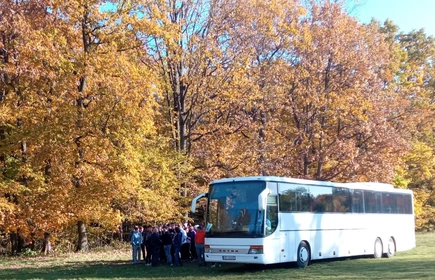 Autobus z wycieczką na tle jesiennego parku