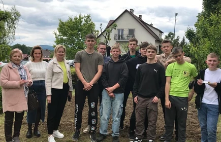 Zdjęcie grupowe - uczniowie CKZiU w Łapanowie wraz z Panią Dyrektor Celiną Jacewicz, Panią Wicedyrektor Alicją Banat i Panią Joanną Żarską-Musiał. Fotografia wykonana w szkolnym ogrodzie.