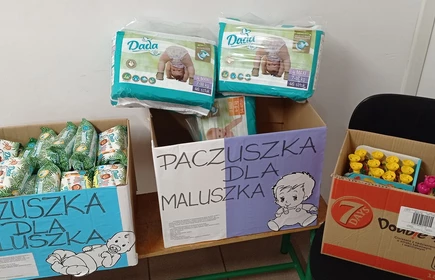 Zdjęcie przedstawia paczki z produktami dla dzieci zgromadzonymi w ramach ubiegłorocznej akcji „Paczuszka dla maluszka” przeprowadzonej w CKZiU w Łapanowie.