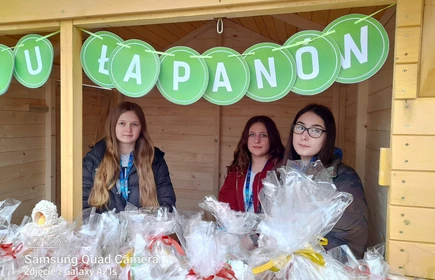 Na zdjęciu od lewej: Karolina Duda (kl. 2 TA), Katarzyna Mentel (kl. 2 TA) i Wanda Malarczyk (kl. 2 TA) na tle wielkanocnego stoiska CKZiU w Łapanowie.
