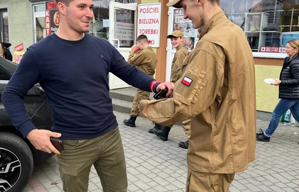 Na zdjęciu uczniowie klasy pożarniczej CKZiU w Łapanowie wraz mieszkańcami Łapanowa i okolic podczas akcji „Noś odblaski”. Fotografia barwna wykonana w centrum Łapanowa.