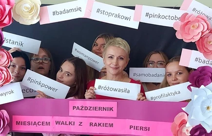 Na zdjęciu p. dyrektor Dorota Matlęga i uczennice uczestniczące w warsztatach.  Zdjęcie wykonane na tle fotobudki promującej profilaktykę raka piersi.
