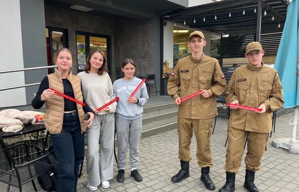 Na zdjęciu uczniowie klasy pożarniczej CKZiU w Łapanowie wraz mieszkańcami Łapanowa i okolic podczas akcji „Noś odblaski”. Fotografia barwna wykonana w centrum Łapanowa.