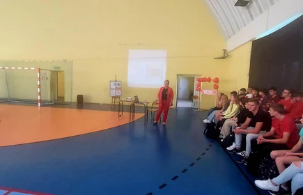 Fotografia barwna: prowadząca - Pani Iwona Świętek wraz z młodzieżą uczestniczącą w Akcji "Czytamy z Sercem". Zdjęcia wykonane w Hali Sportowej CKZiU w Łapanowie.