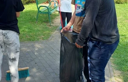 Na zdjęciu młodzież porządkuje plac zabaw.