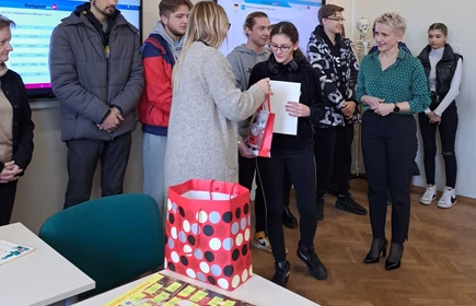 Na zdjęciu wręczenie nagród i dyplomów  uczestnikom przez panią dyrektor Dorotę Matlęgę, panią Ewę Sudziarską i panią Lucynę Zajd. Nagrodę odbiera laureatka pierwszego miejsca - Jessica Kapera. W tle pozostali uczestnicy konkursu.