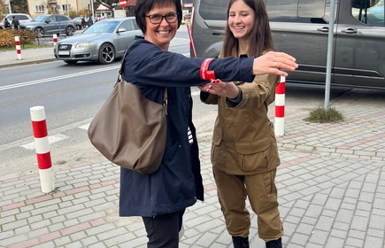 Na zdjęciu uczniowie klasy pożarniczej CKZiU w Łapanowie wraz mieszkańcami Łapanowa i okolic podczas akcji „Noś odblaski”. Fotografia barwna wykonana w centrum Łapanowa.