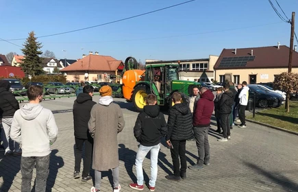 Na zdjęciu uczestnicy szkolenia z zakresu stosowania środków ochrony roślin przy ciągniku z opryskiwaczem podczas części praktycznej kursu. Zdjęcie wykonano na placu przy budynku "B" CKZiU w Łapanowie.   