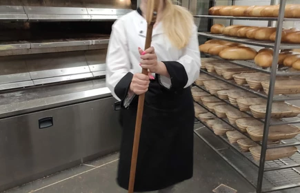 Uczennica układa wypieczony chleb.