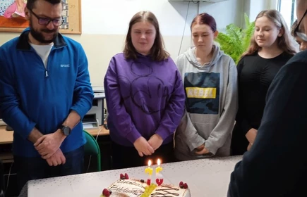 Zgromadzona młodzież wokół tortu urodzinowego