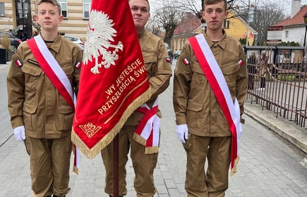 Poczet Sztandarowy CKZiU w Łapanowie na uroczystościach z okazji Narodowego Święta Niepodległości w Bochni. Fotografia barwna wykonana przed Bazylika św. Mikołaja Bpa w Bochni.