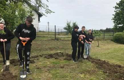 Na zdjęciu uczniowie CKZiU w Łapanowie w czasie przygotowywania poletka do wysiewu ziół i kwiatów. Fotografia wykonana w szkolnym ogrodzie.