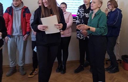 Na zdjęciu wręczenie nagród i dyplomów  uczestnikom przez panią dyrektor Dorotę Matlęgę, panią Ewę Sudziarską i panią Lucynę Zajd. Nagrodę odbiera laureatka trzeciego miejsca - Oliwia Klimek. W tle pozostali uczestnicy konkursu.