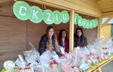 Na zdjęciu od lewej: Karolina Duda (kl. 2 TA), Katarzyna Mentel (kl. 2 TA) i Wanda Malarczyk (kl. 2 TA) na tle wielkanocnego stoiska CKZiU w Łapanowie.