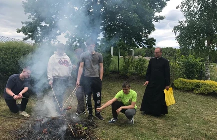 Na zdjęciu uczniowie CKZiU w Łapanowie wraz z Księdzem Łukaszem Kopczyńskim. Fotografia wykonana w szkolnym ogrodzie.