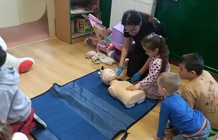 Na zdjęciu uczennica Justyna Kącka i uczestnicy warsztatów prezentują resuscytację z użyciem fantomów.