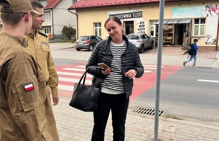 Na zdjęciu uczniowie klasy pożarniczej CKZiU w Łapanowie wraz mieszkańcami Łapanowa i okolic podczas akcji „Noś odblaski”. Fotografia barwna wykonana w centrum Łapanowa.