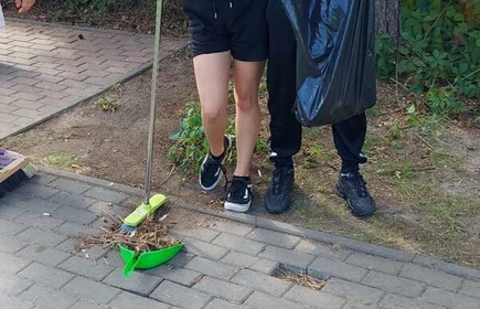 Na zdjęciu młodzież porządkuje plac zabaw.