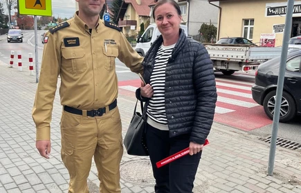 Na zdjęciu uczniowie klasy pożarniczej CKZiU w Łapanowie wraz mieszkańcami Łapanowa i okolic podczas akcji „Noś odblaski”. Fotografia barwna wykonana w centrum Łapanowa.