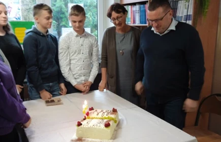 Zgromadzona młodzież wokół tortu urodzinowego