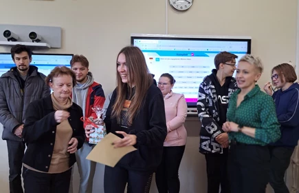 Na zdjęciu wręczenie nagród i dyplomów  uczestnikom przez panią dyrektor Dorotę Matlęgę, panią Ewę Sudziarską i panią Lucynę Zajd. Nagrodę odbiera laureatka trzeciego miejsca - Oliwia Klimek. W tle pozostali uczestnicy konkursu.