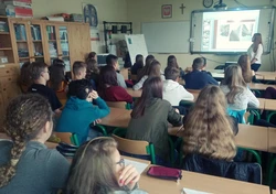 grupa osób w klasie wpatrzona w ekran rzutnika