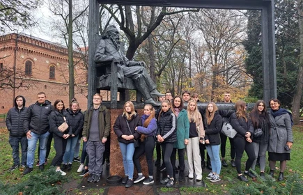 Grupowe zdjęcie uczestników wycieczki pod pomnikiem Jana Matejki w Krakowie. 