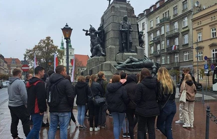 Grupowe zdjęcie uczestników wycieczki pod Pomnikiem Grunwaldzkim w Krakowie.
