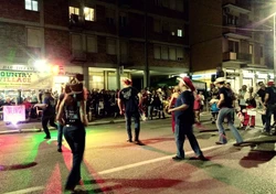 grupa ludzi idących nocą ulicą